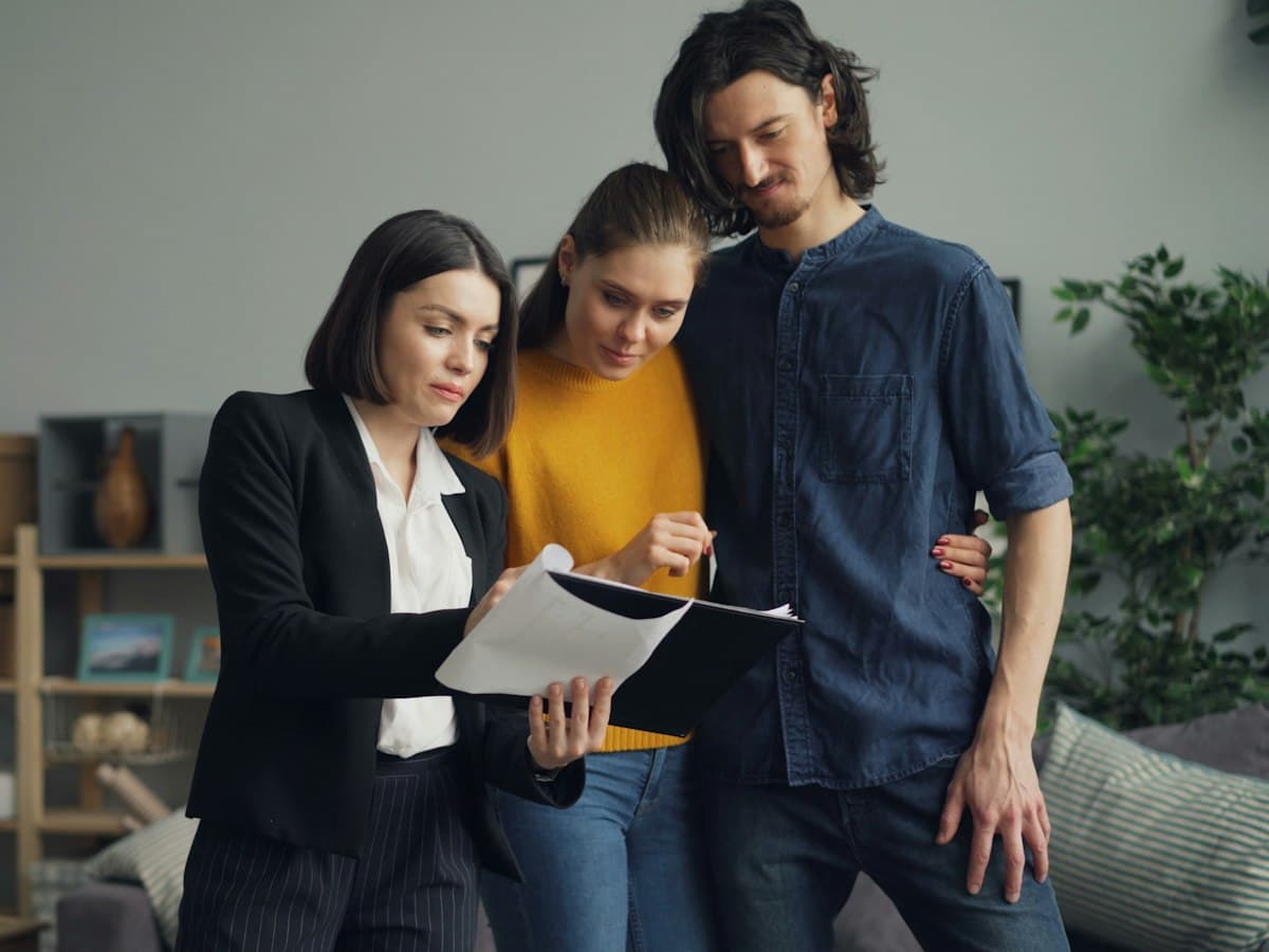An agent going through paperwork with a couple in a living room